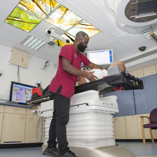 radiotherapy room with staff member and patient